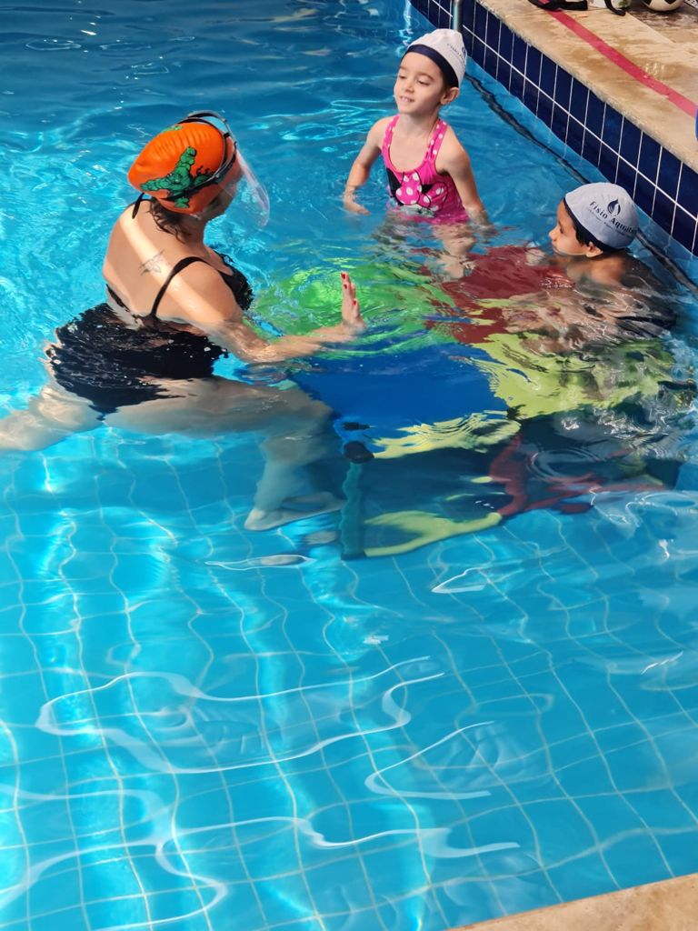 Crianças em atividade aquática com acompanhamento profissional na piscina aquecida da Fisio Aquática
